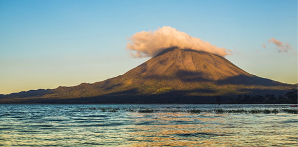 A mountain rising above a body of water.