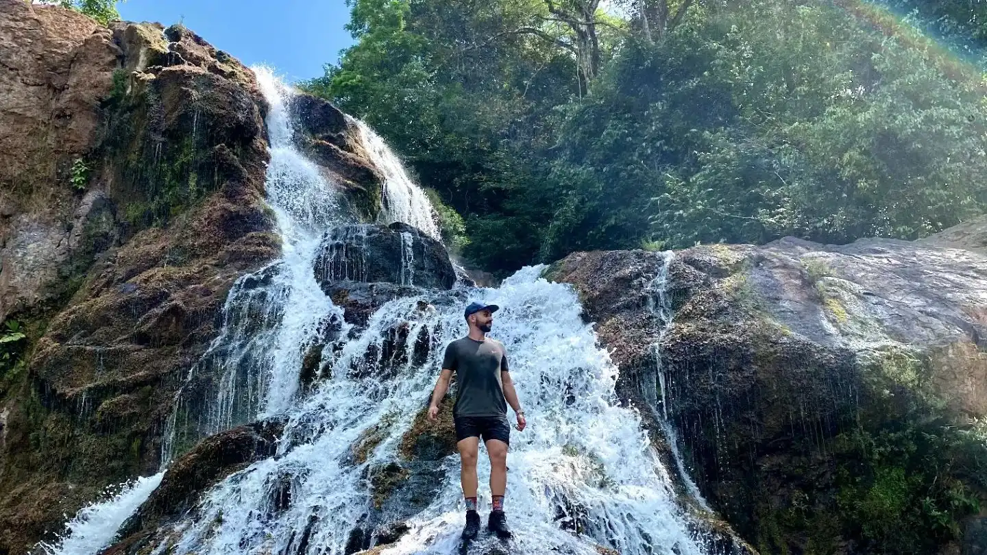 A man standing in front of a waterfall