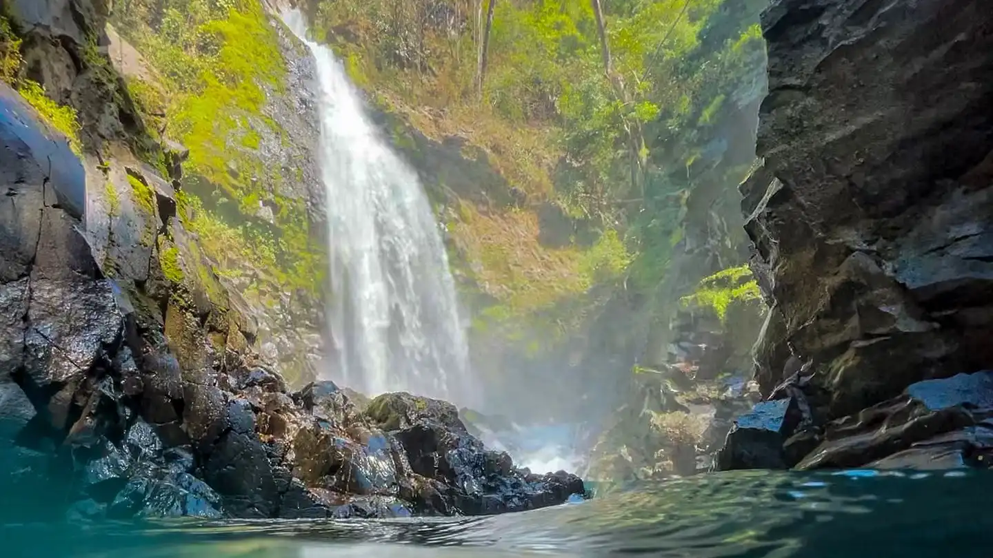 A waterfall in the middle of a body of water.