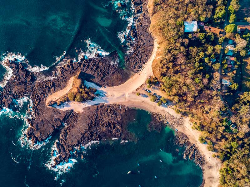 An aerial view of a sandy beach and ocean.