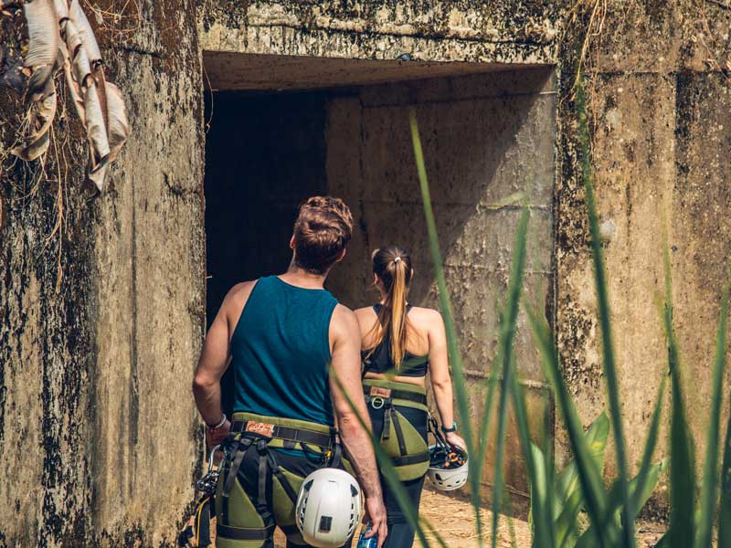 A man and a woman walking out of a cave.