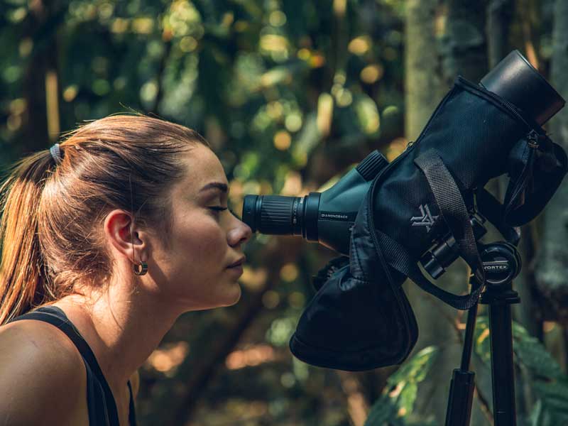 A woman looking through a pair of binoculars.