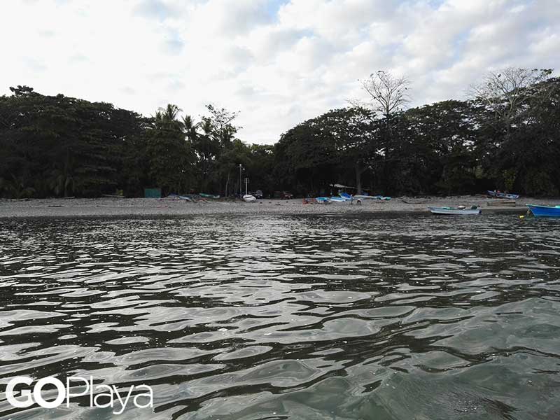 Un cuerpo de agua con barcos al fondo.