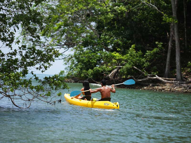 A man is paddling a kayak in the water.