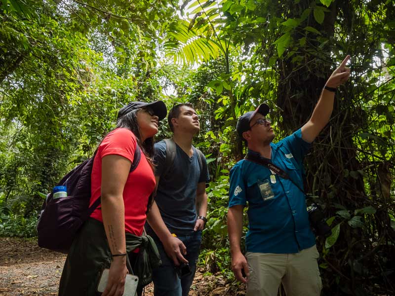 A group of people standing next to each other in a forest .