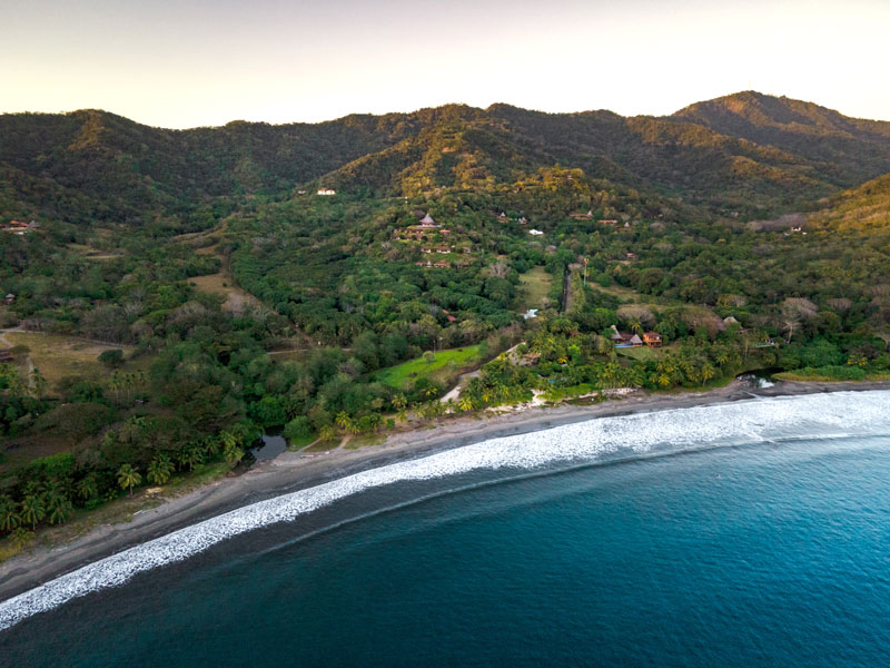 Una vista aérea de una playa y montañas.