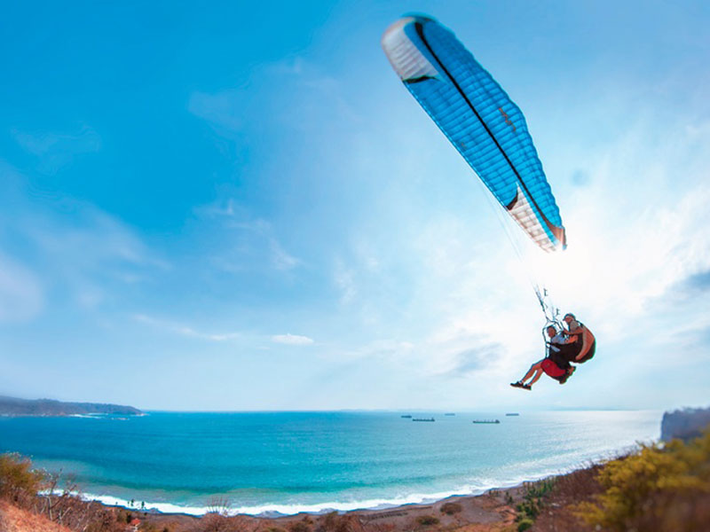 A man flying through the air while riding a kiteboard