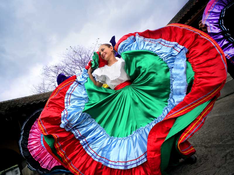 A woman in a colorful dress dancing.