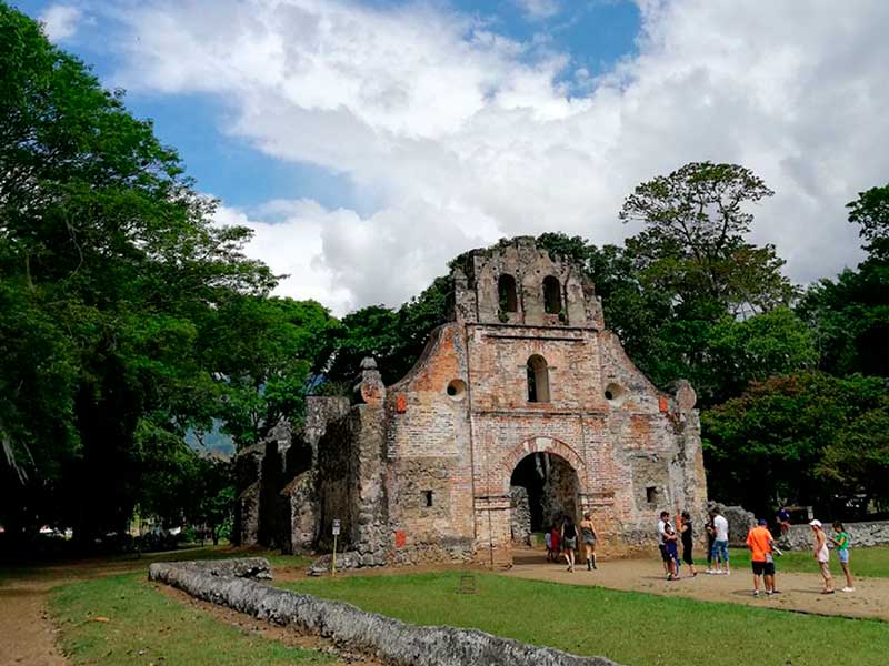 A group of people standing in front of a stone building.