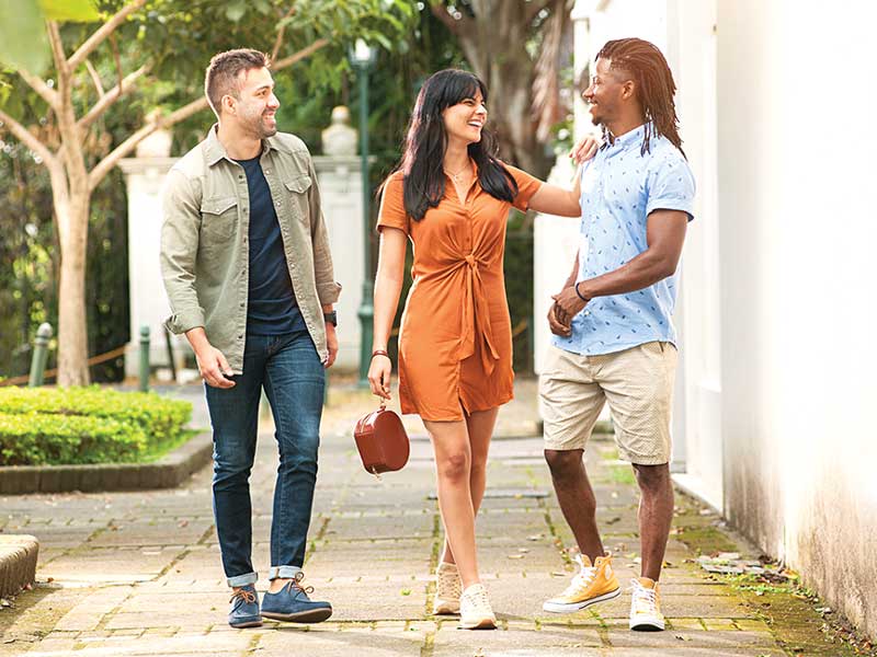 A group of people walking down a sidewalk.