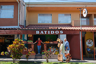 A couple of people standing outside of a store.