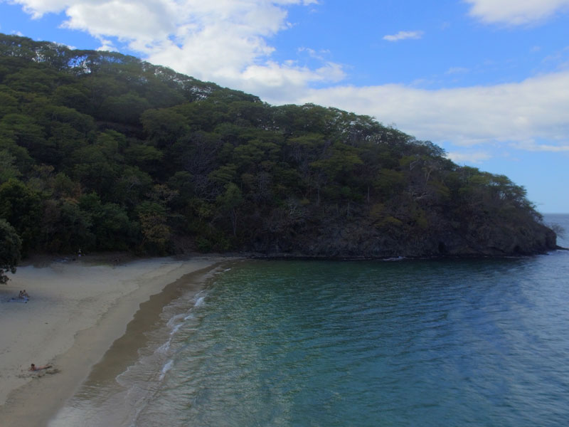 A view of a beach with a mountain in the background.