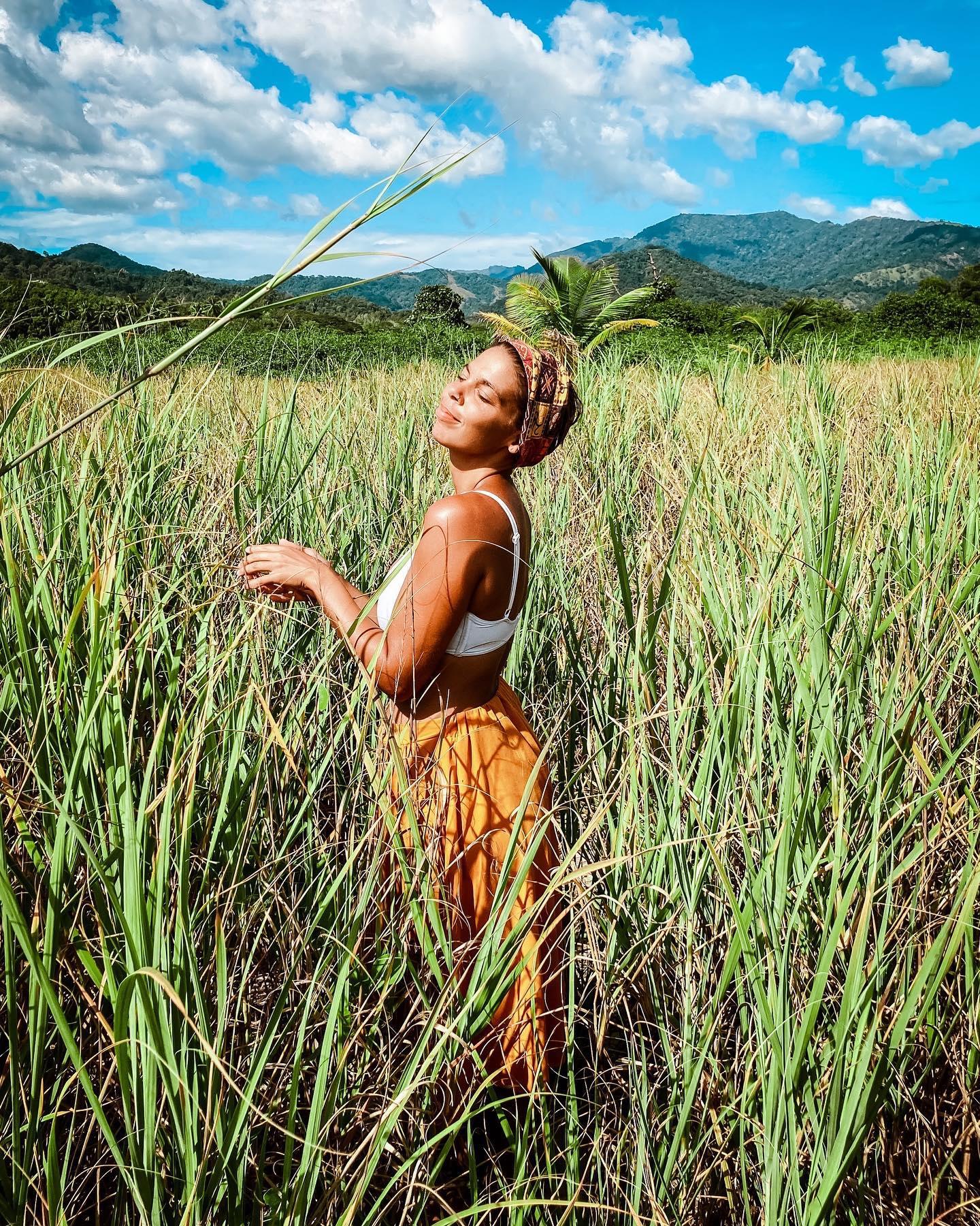 A woman standing in a field of tall grass
