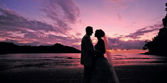 bride and groom on beach at sunset