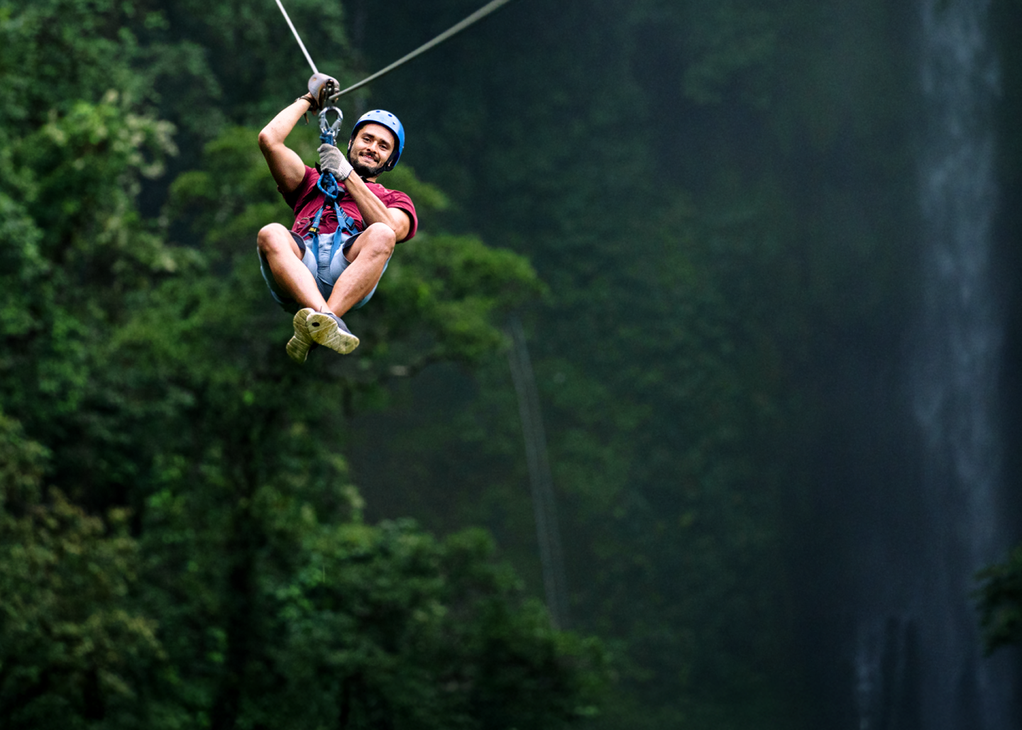 Man ziplining through forest
