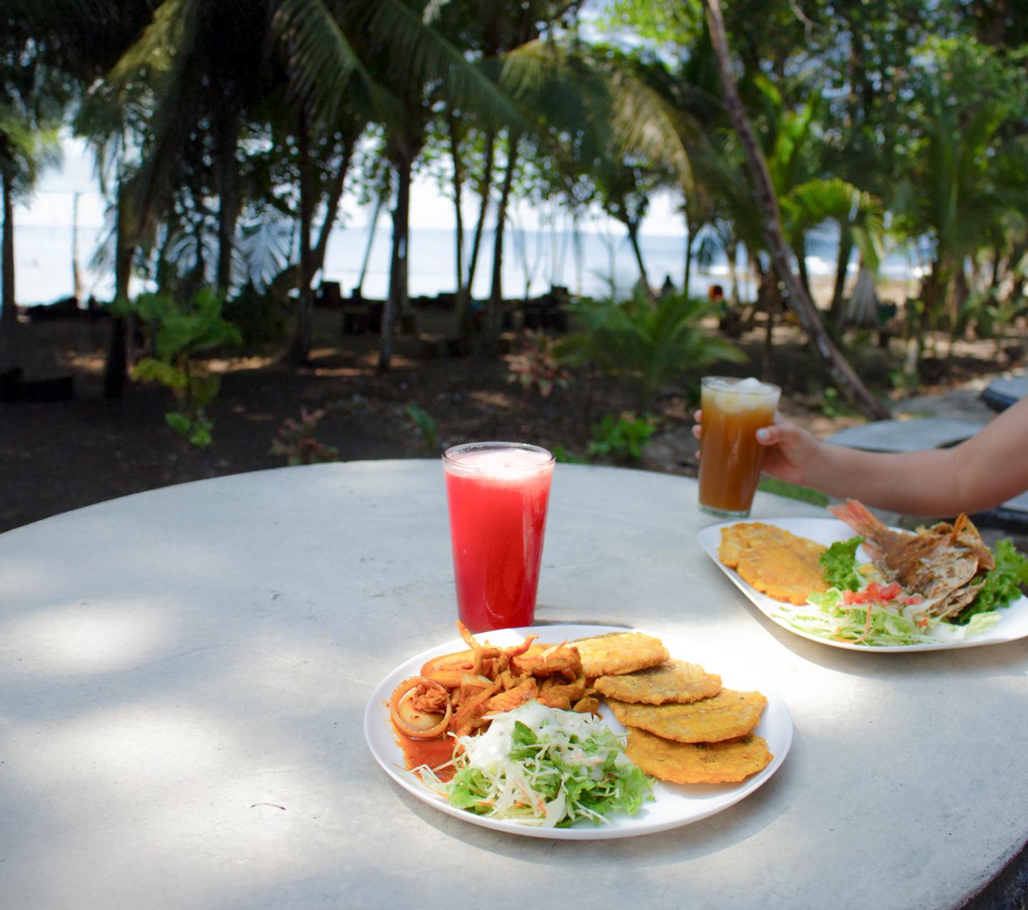 two dishes on a table outside with a beach view
