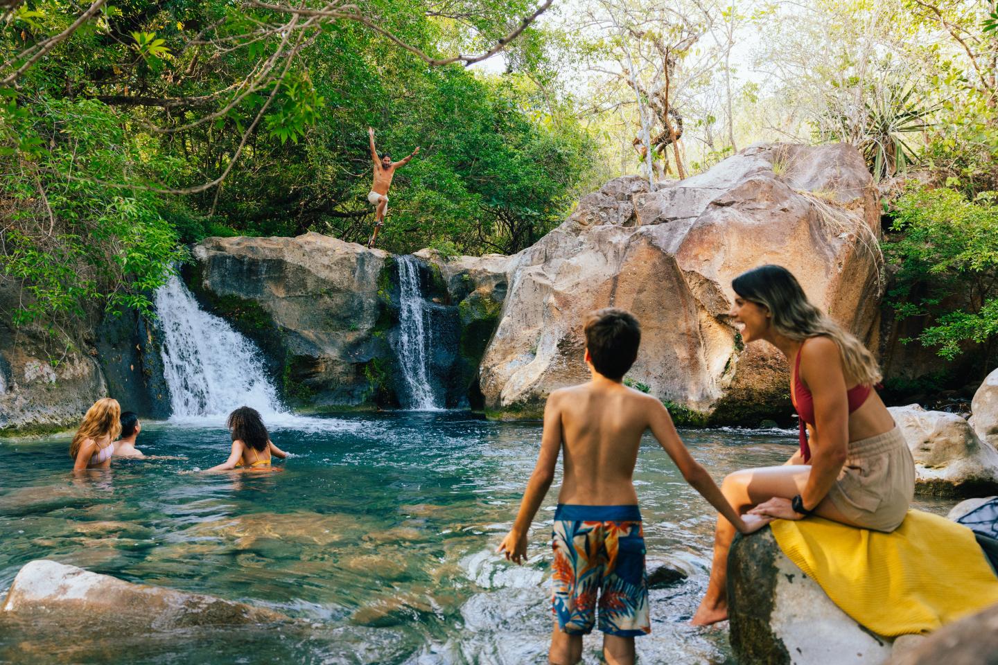 family swimming in a spring in jungle