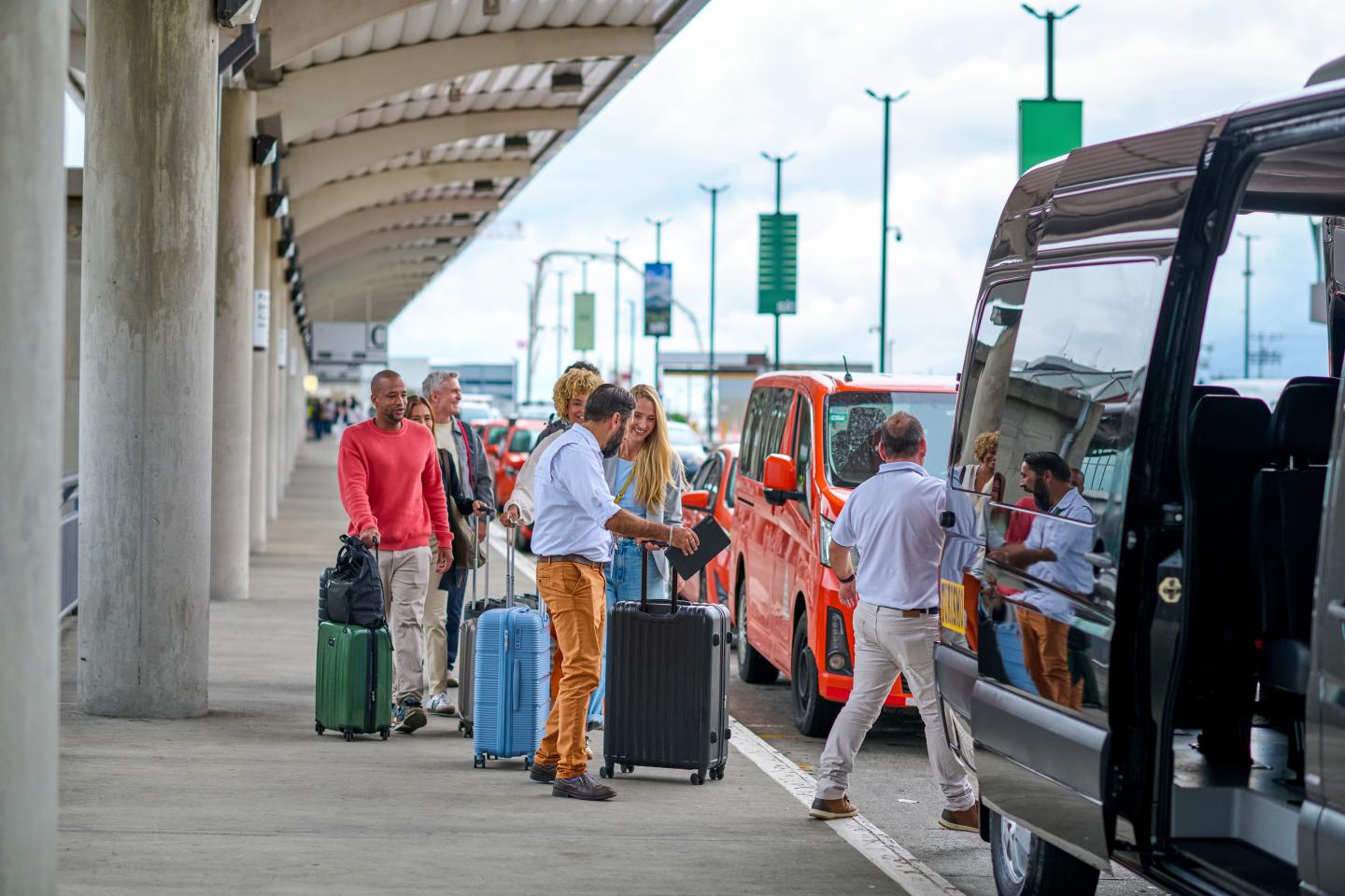 man helping family with suitcases at airport